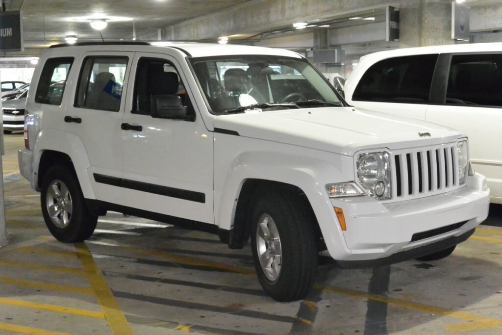 White four-door jeep in a parking lot.  Illustrative image of text on how to care for a white car.
