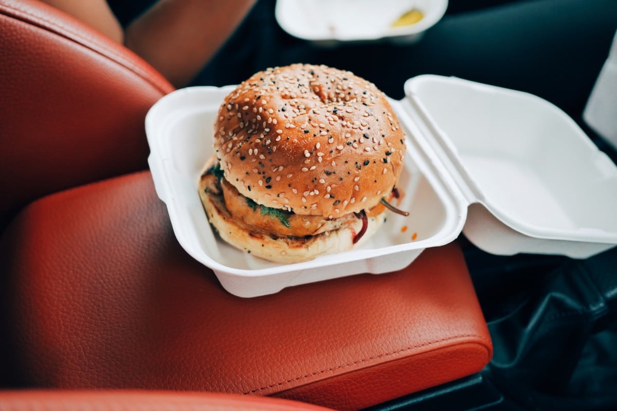 Packaging with hamburger on the red leather upholstery. 