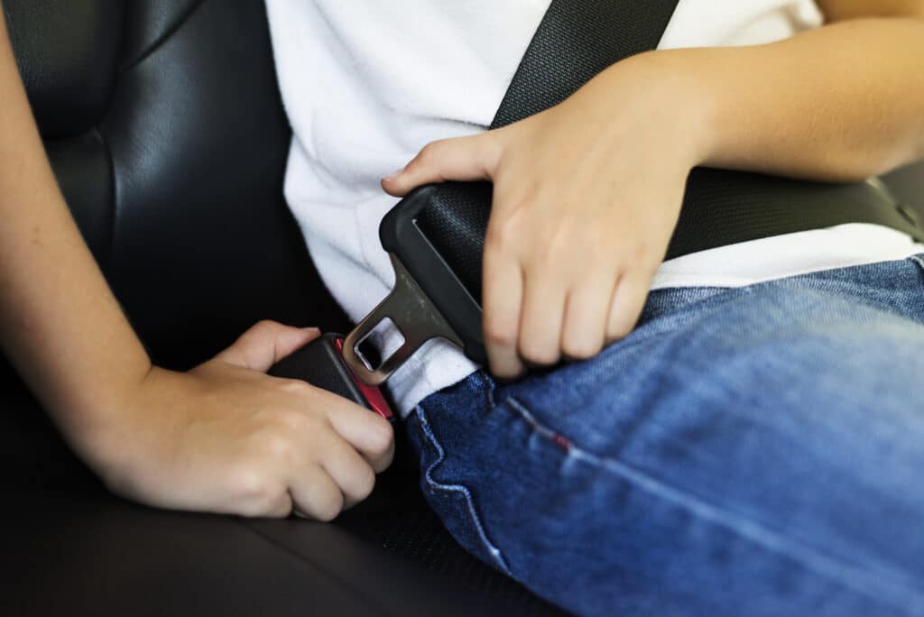 photo of a child putting his seat belt in a car.  illustrative image for the contents cleaning of upholstery itu sp also takes care of the car seats