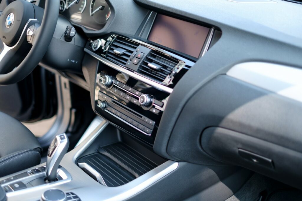 Interior de BMW, com volante, câmbio, rádio, ar-condicionado, painel, console e tela de LCD. Imagem do conteúdo limpeza de ar-condicionado em Palmas.