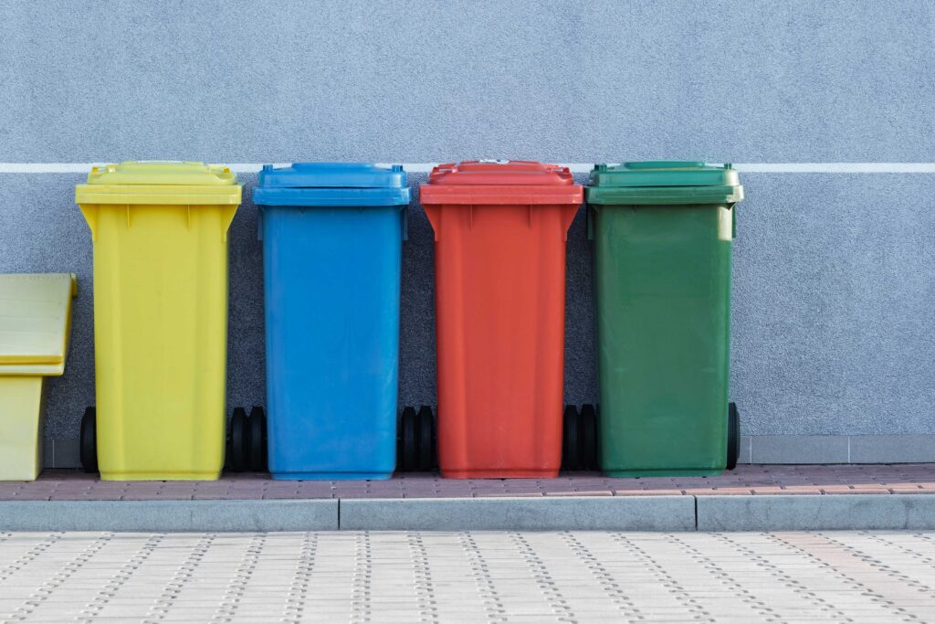 latas de lixo reciclavéis, cada uma em uma cor indicando a finalidade dos lixos que devem ser descartados ali. Essa é uma das práticas da higiene ambiental.