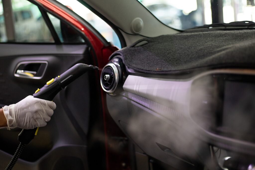 Equipamento de limpeza de ar-condicionado sendo aplicado na saída de ar dentro do carro. Imagem ilustrativa do texto higienização de ar-condicionado no Piauí.