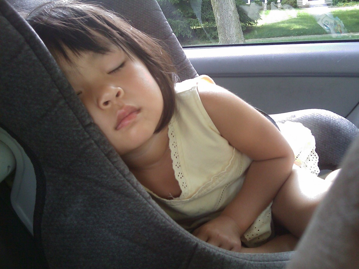 Menina dormindo na cadeirinha no interior do veículo. Imagem do conteúdo sobre limpeza interna de carros.