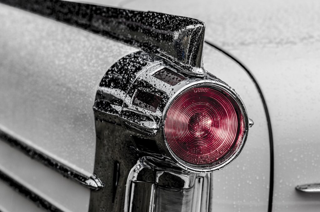 Close na lanterna traseira de um carro antigo da cor branca. Imagem ilustrativa texto lava jato no Ceará.
