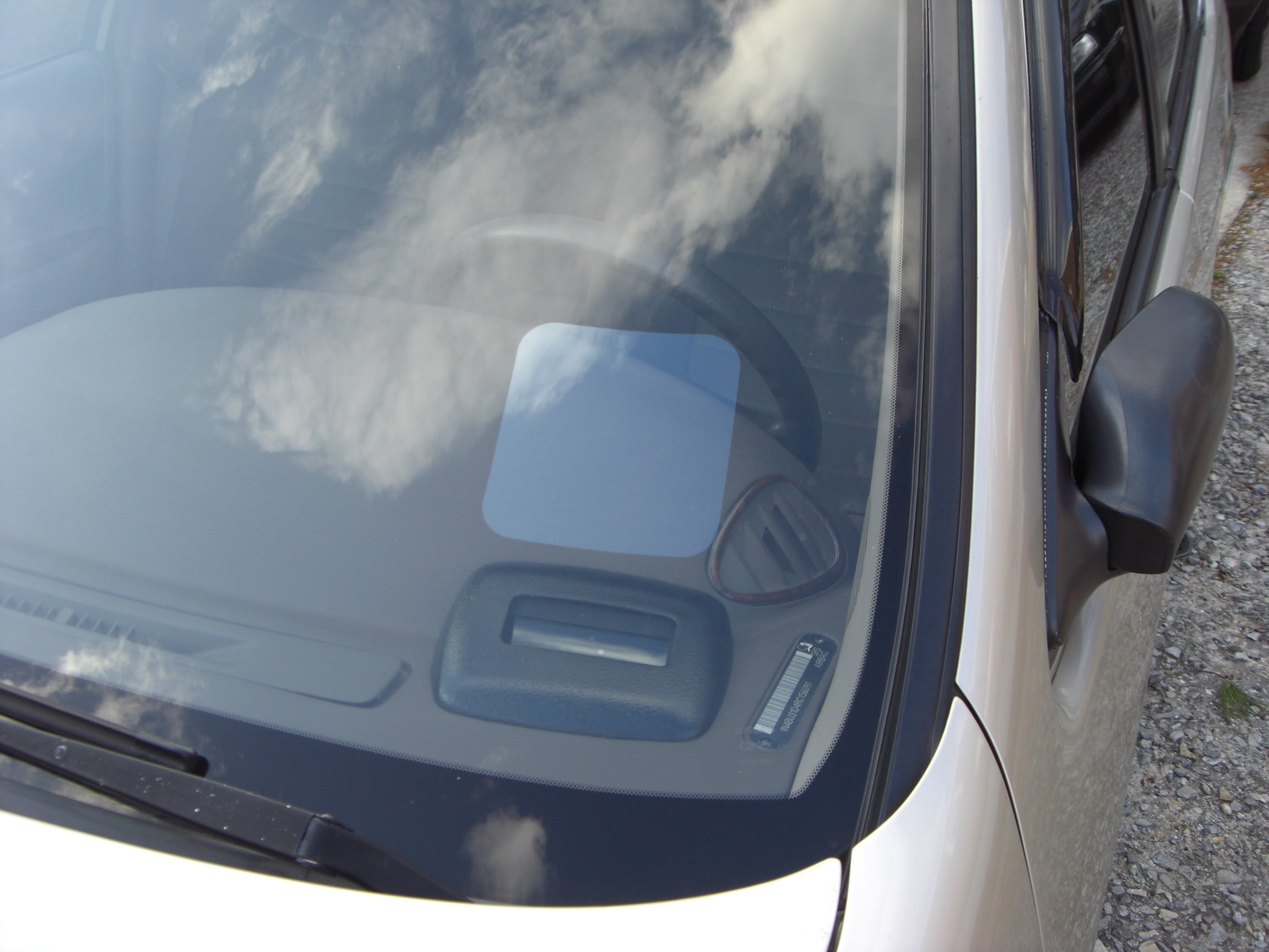 Detalhe do para-brisa do carro branco. Imagem ilustrativa texto mancha no vidro do carro.