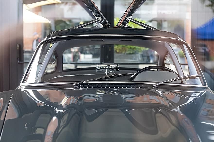 Para-brisa de carro esportivo com asas de gaivota. Imagem do conteúdo como limpar os vidros do carro.