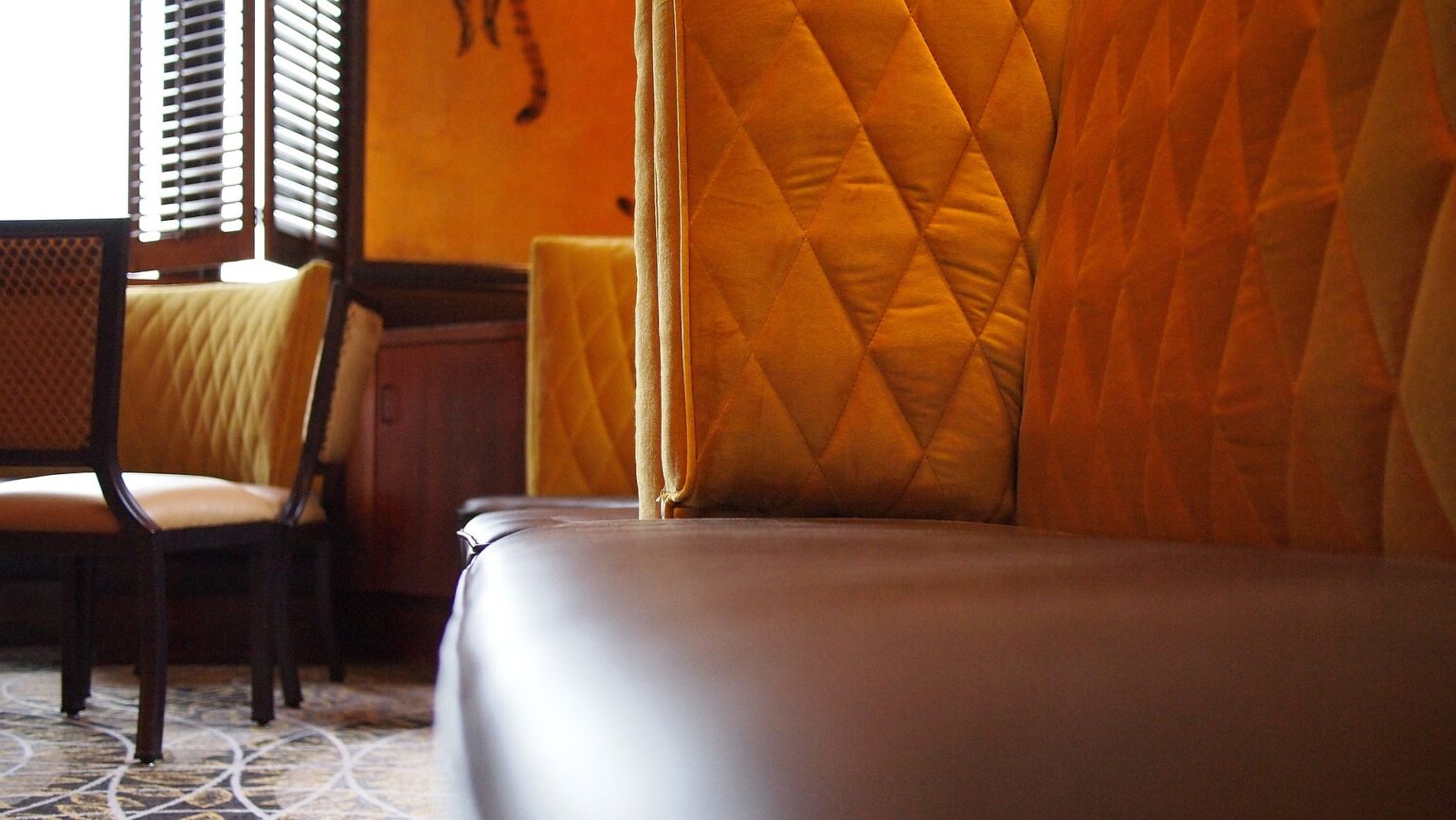 Sofá, cadeirase parede estofada em restaurante. Imagem ilustrativa texto lavar sofá Congonhinhas.