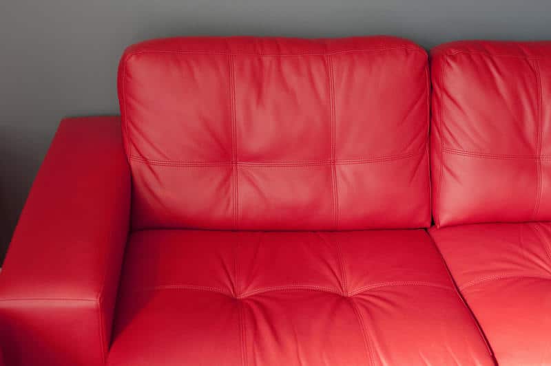 Canto de sofá de couro vermelho. Imagem ilustrativa texto lavar sofá Congonhinhas.