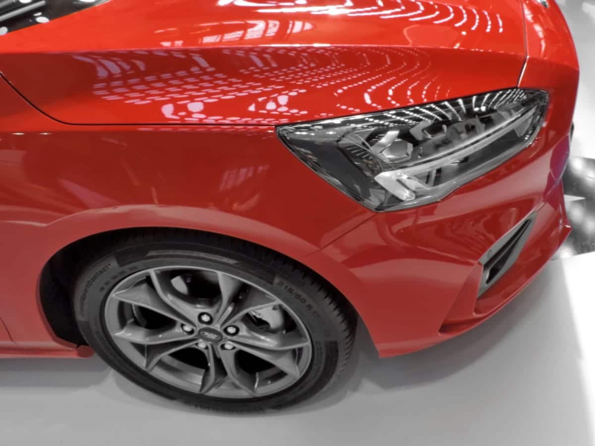 Detalhe dianteira de carro vermelho. Imagem ilustrativa texto para que serve o polimento.