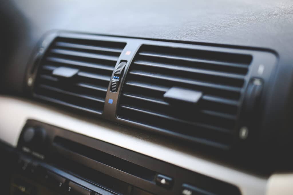 Imagem focada em aparelho de ar-condicionado de carro. Todas as peças são pretas. Imagem ilustrativa do texto lavar carro Alphaville.