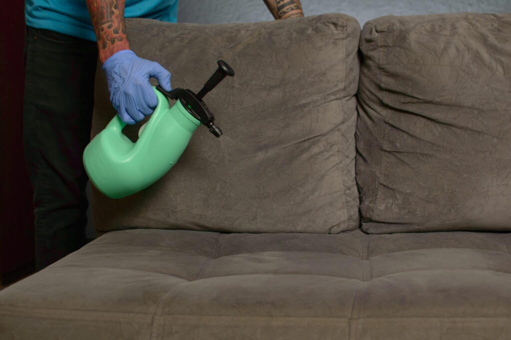 Funcionário Acquazero realizando limpeza de sofá importante para desinfecção de ambientes. 