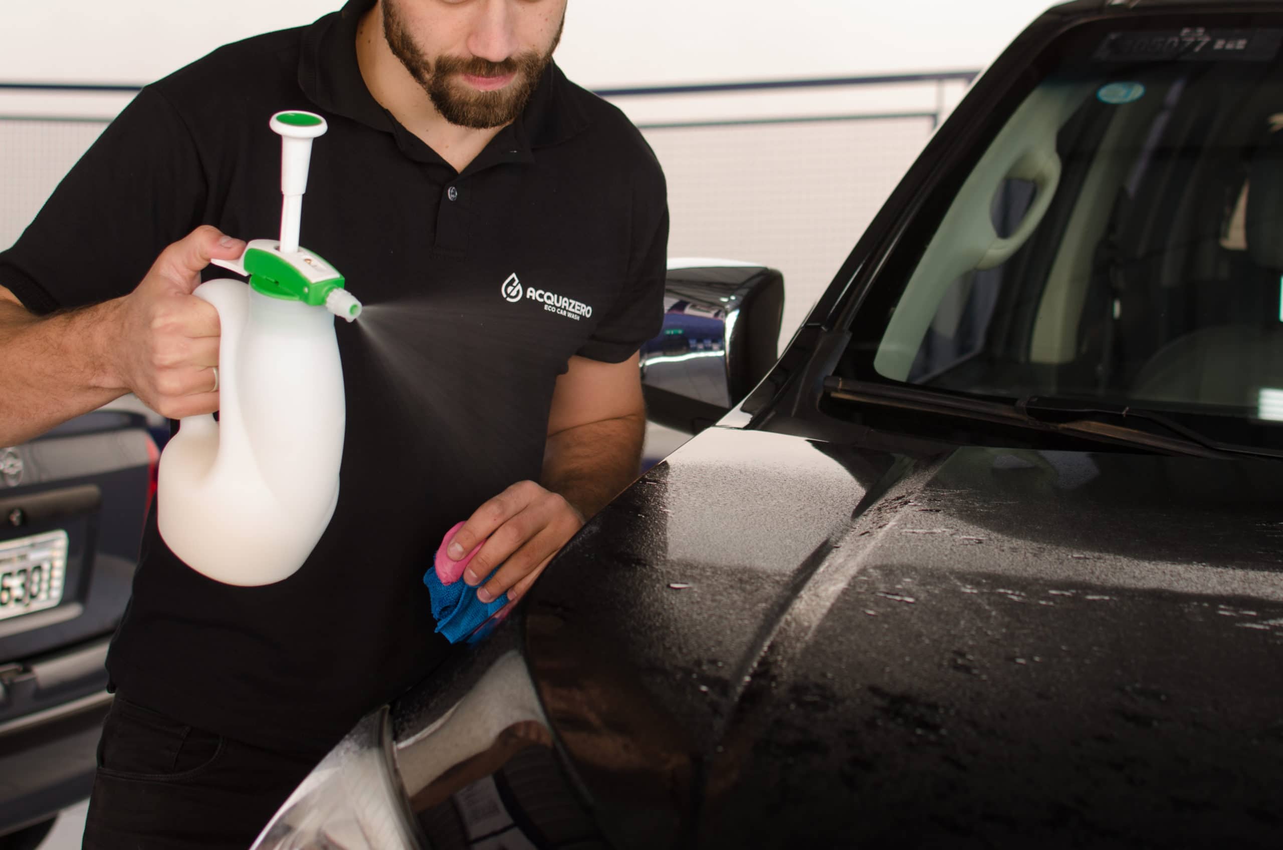 Homem limpa o carro com o auxílio de um borrifador. Ilustração do texto lava rápido no Shopping D.
