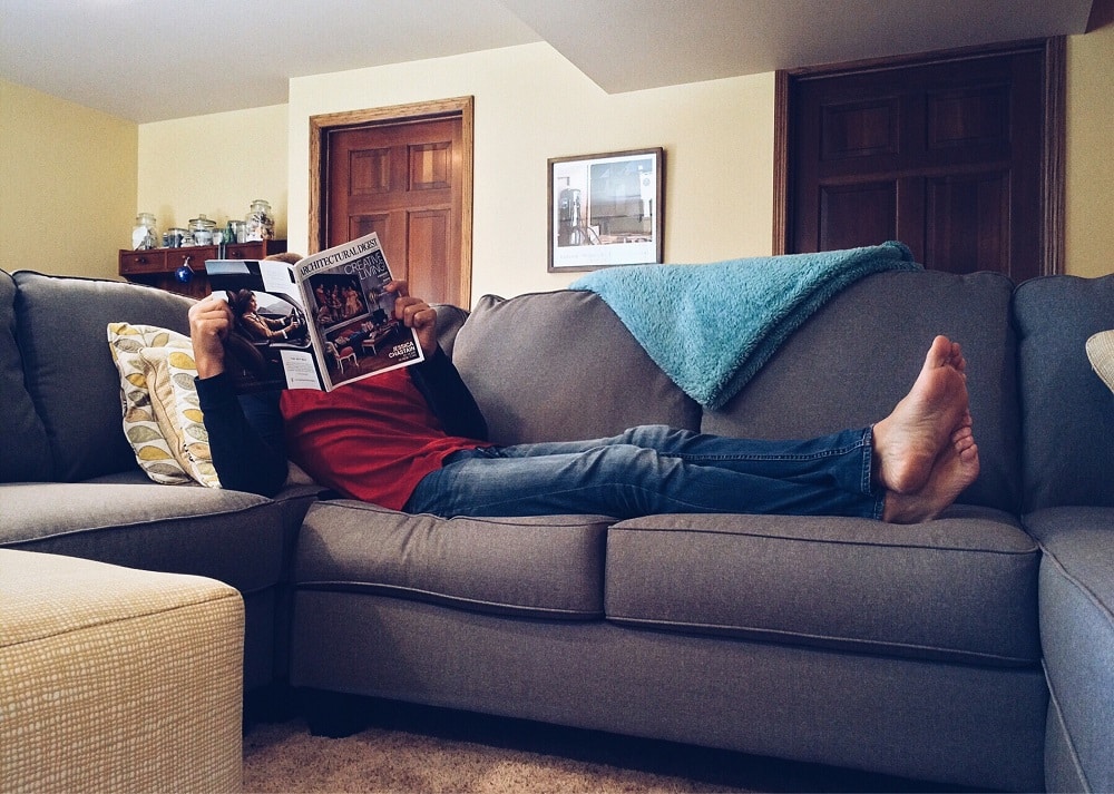 homem deitado em sofá segurando revista ilustração texto limpar sofá centro de barretos