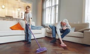 Menino de caminha cinza ajuda um senhor a limpar o chão da casa. ilustração limpar sofa montanha es