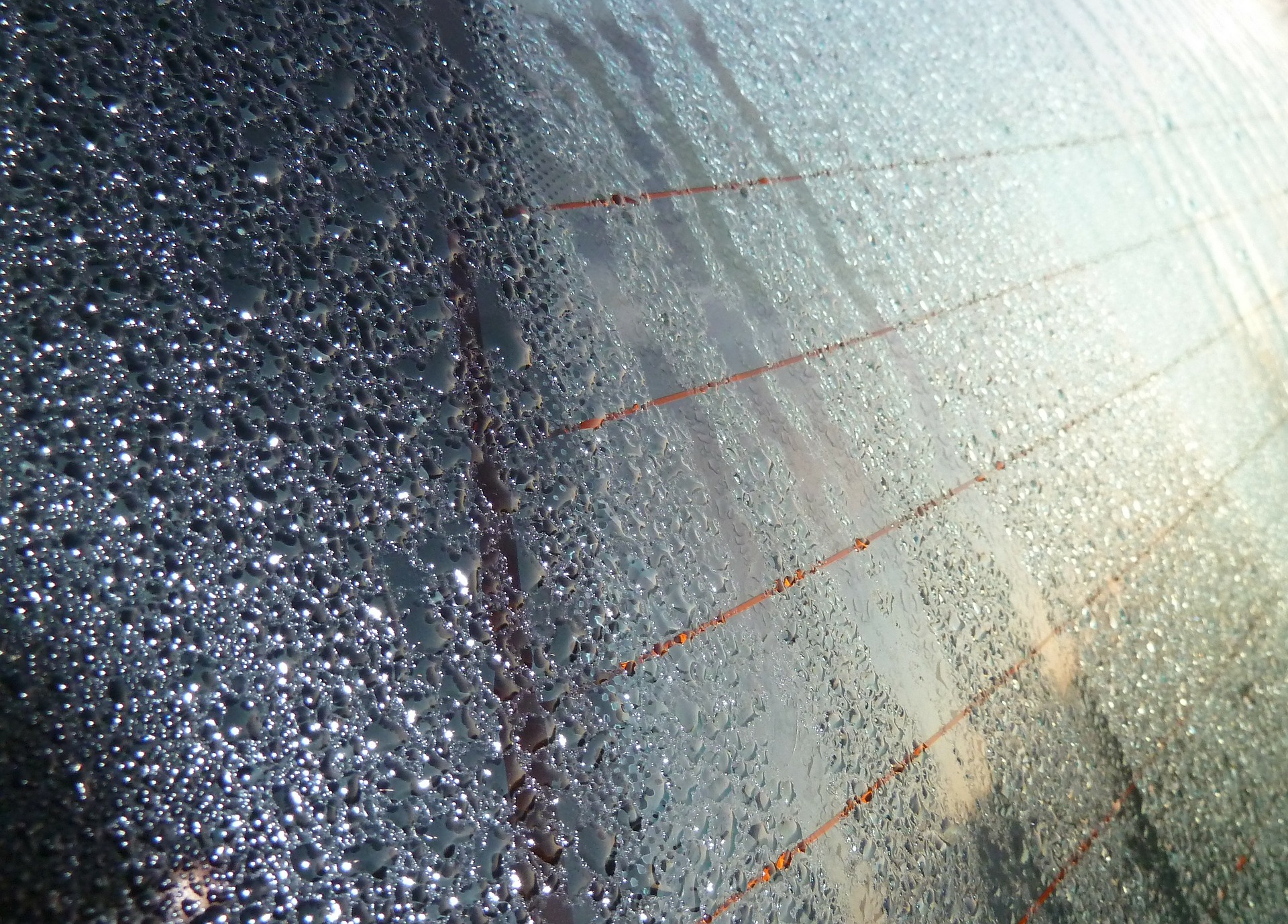 Foto da janela molhada de um carro. Imagem ilustrativa para o texto descontaminação de vidros.