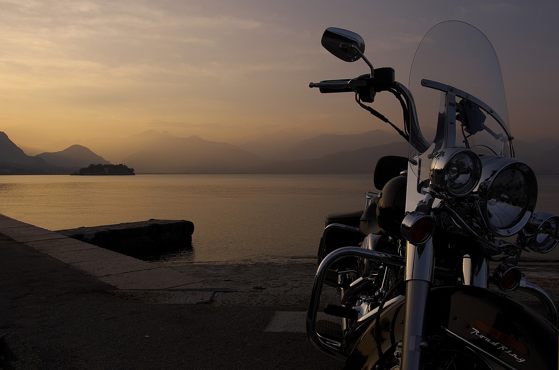 Foto de uma moto parada e uma paisagem ao fundo. Imagem ilustrativa para o texto lavagem detalhada de moto.