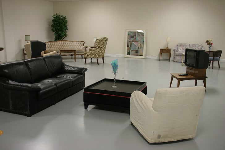Sala de estar ampla com sofás em tons claros e marrom. Ilustração do texto sobre limpar sofá no Centro de Itabirito.