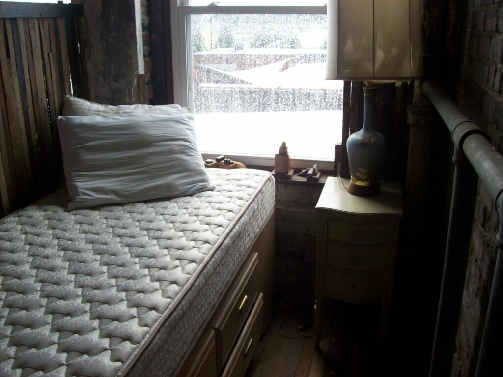 Colchão sem roupa de cama em um quarto. Imagem ilustrativa do texto sobre como  tirar mau cheiro do colchão.