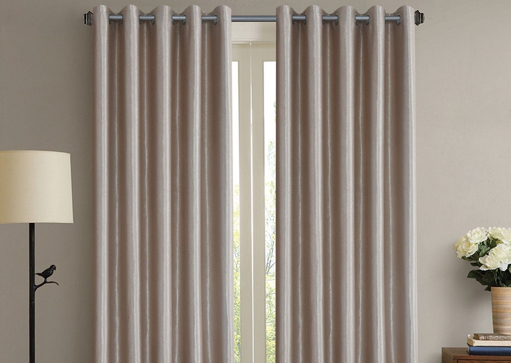 Cortina branca com um abajur na lateral da foto; imagem ilustrativa texto sobre lavar cortina com blackout