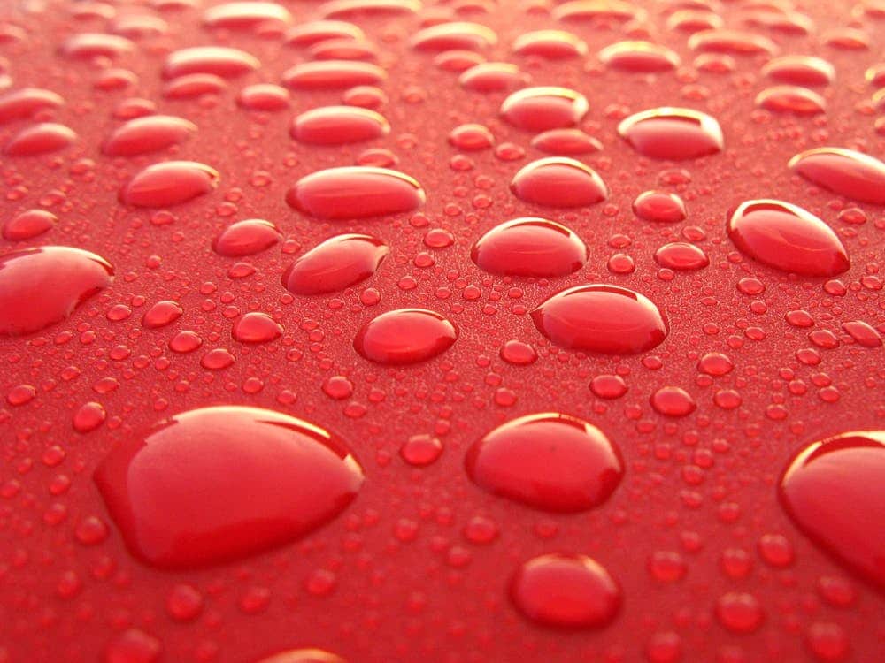 lataria vermelha do carro com gotas de água