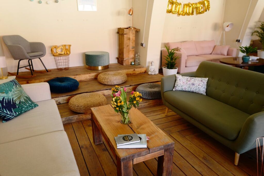 Sala com chão e mesa de madeira e estofados de diferentes cores. Imagem ilustrativa do texto sobre fazer limpeza a seco em casa 