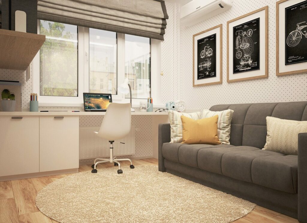 quanto claro com um sofá de três lugares cinza e uma escrivaninha com um computador em frente á janela. imagem de texto sobre empresas de limpeza doméstica