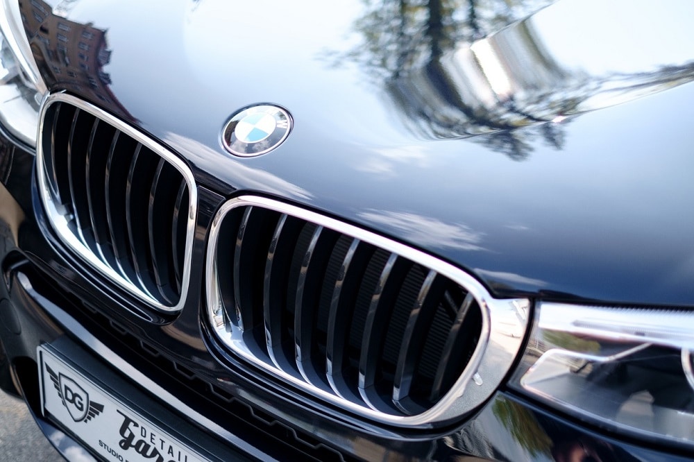 Imagem da frente de um carro BMW preto com o foco nos faróis e na grade dianteira. Imagem ilustrativa texto lavagem automotiva profissional.